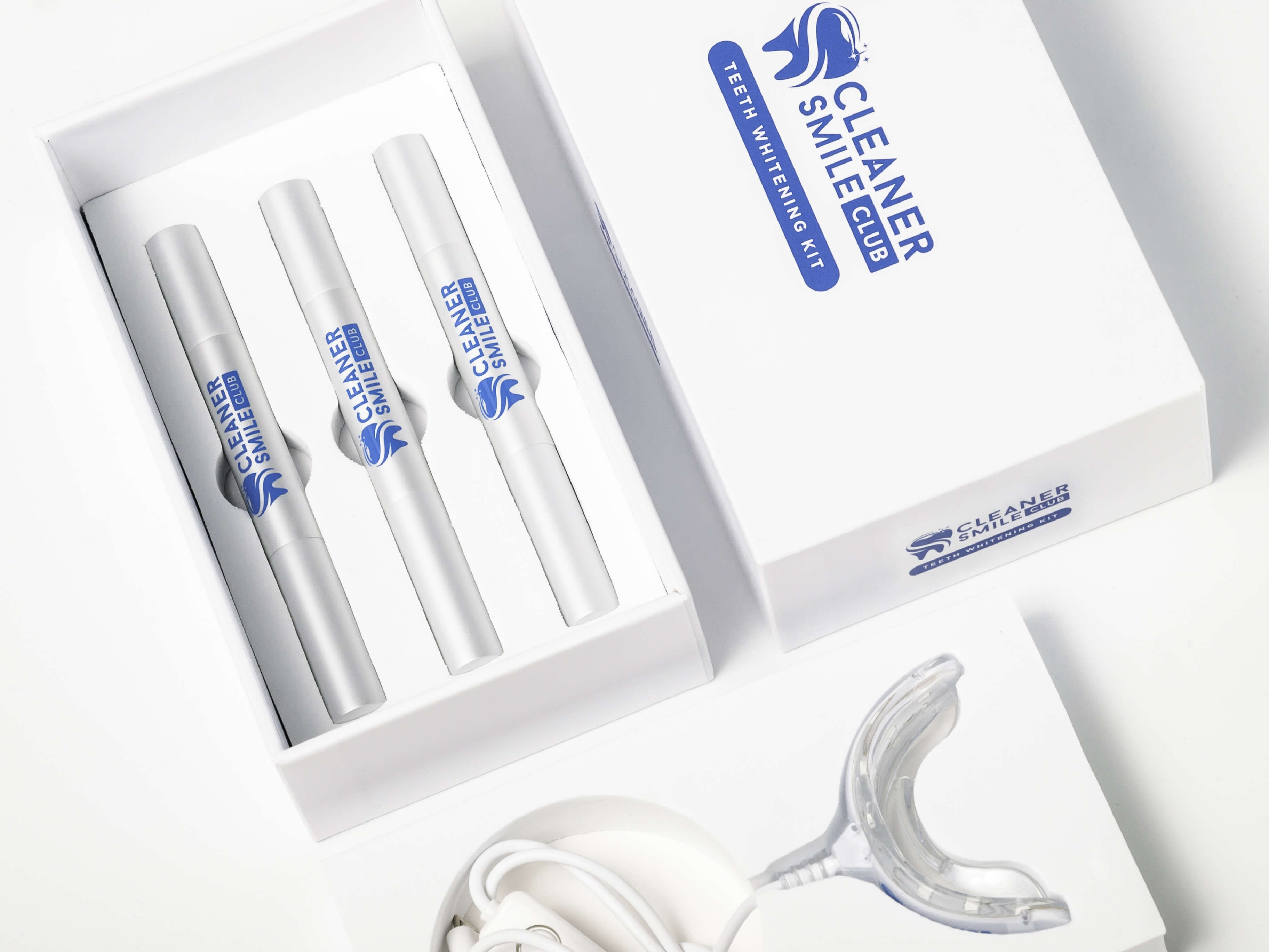 Cosmetic teeth whitening white kit from Cleaner Smile Club brand on white background with 3 whitening pens and LED mouth piece photo made by Fantastic Imago Branding, Advertising and Consulting Agency