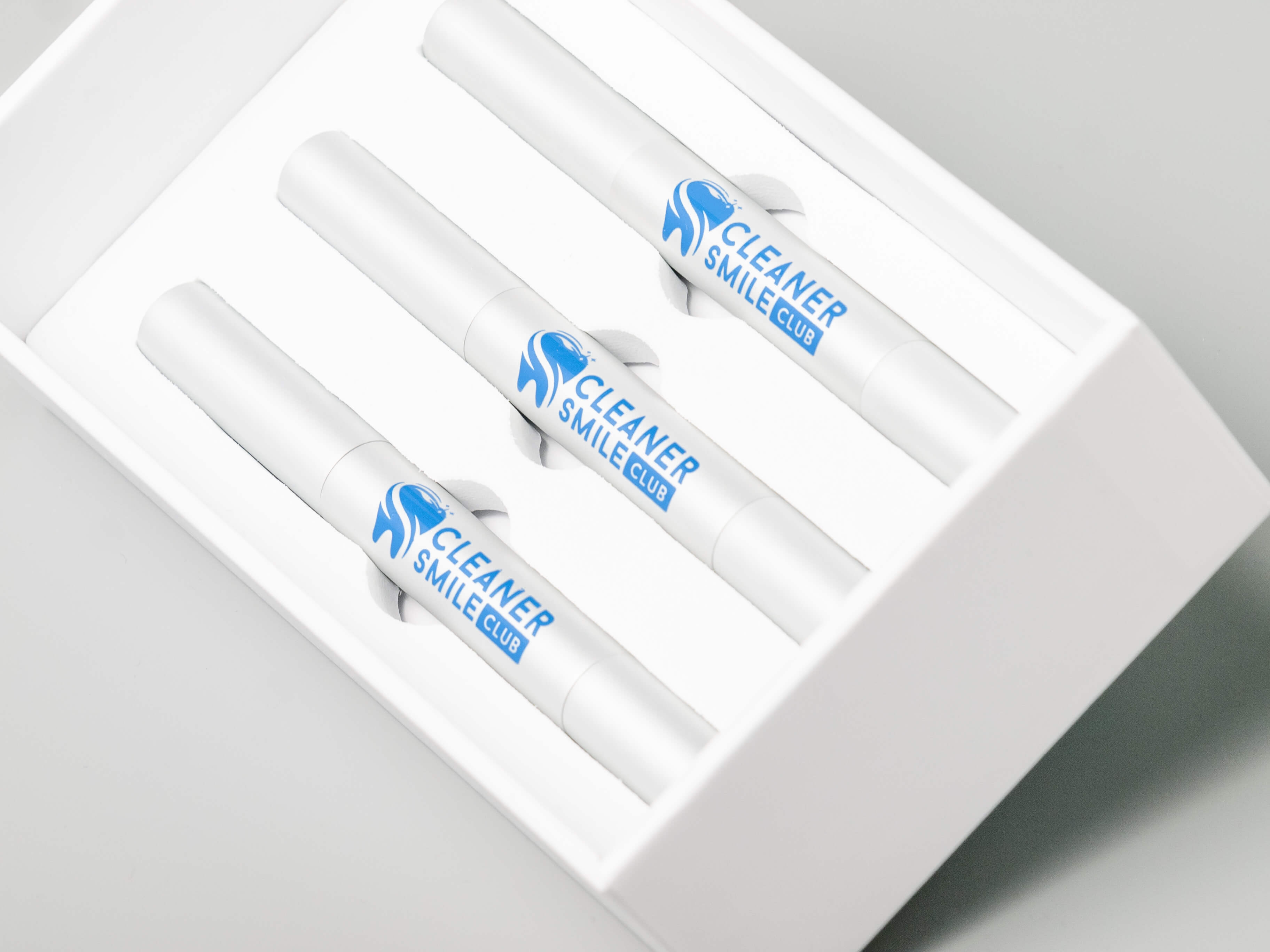 teeth whitening pen white kit from Cosmetic Cleaner Smile Club Brand white box on the grey background still photography production made by Fantastic Imago Branding, Advertising and Consulting Agency